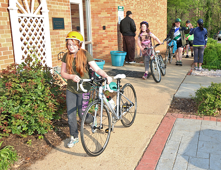 Students at Campbell Elementary School walk their bikes on campus.